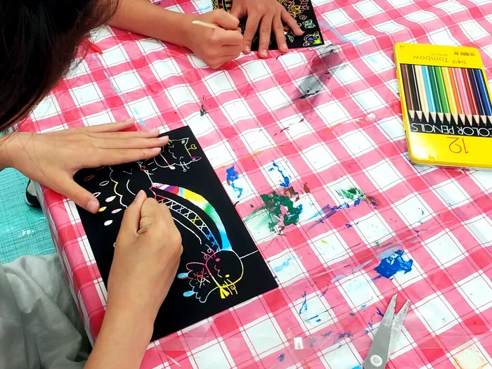 スクラッチアートを制作する子供の手元